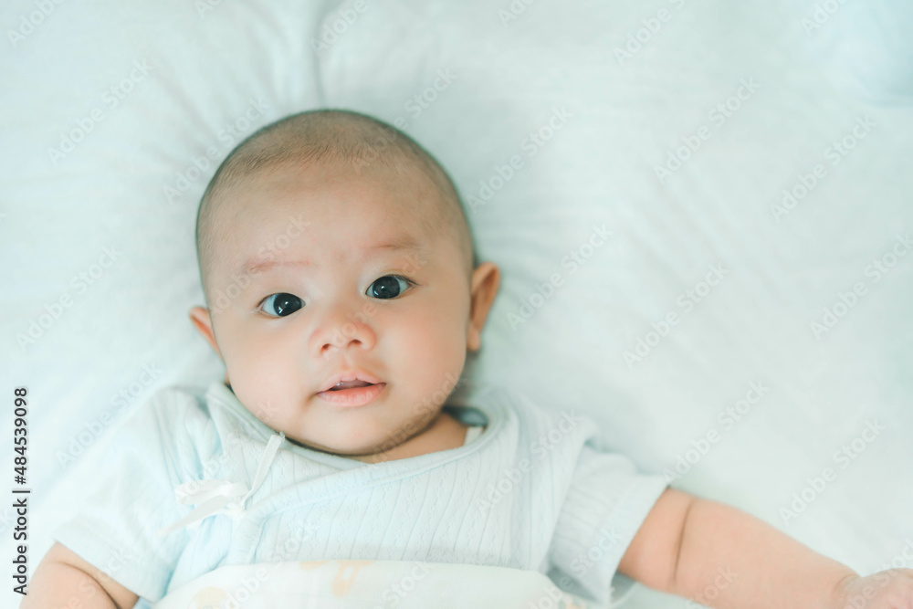 Adorable, Asian newborn. Baby boy looking camera and smile happy face. Little innocent new infant child in first day of life. Mother day concept.
