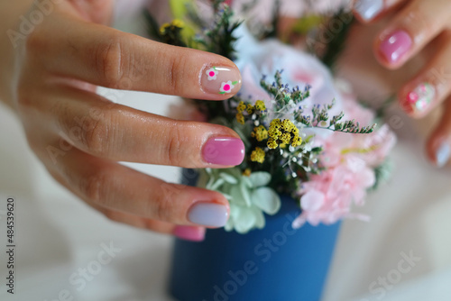 woman s hand in pink and white nail art.
