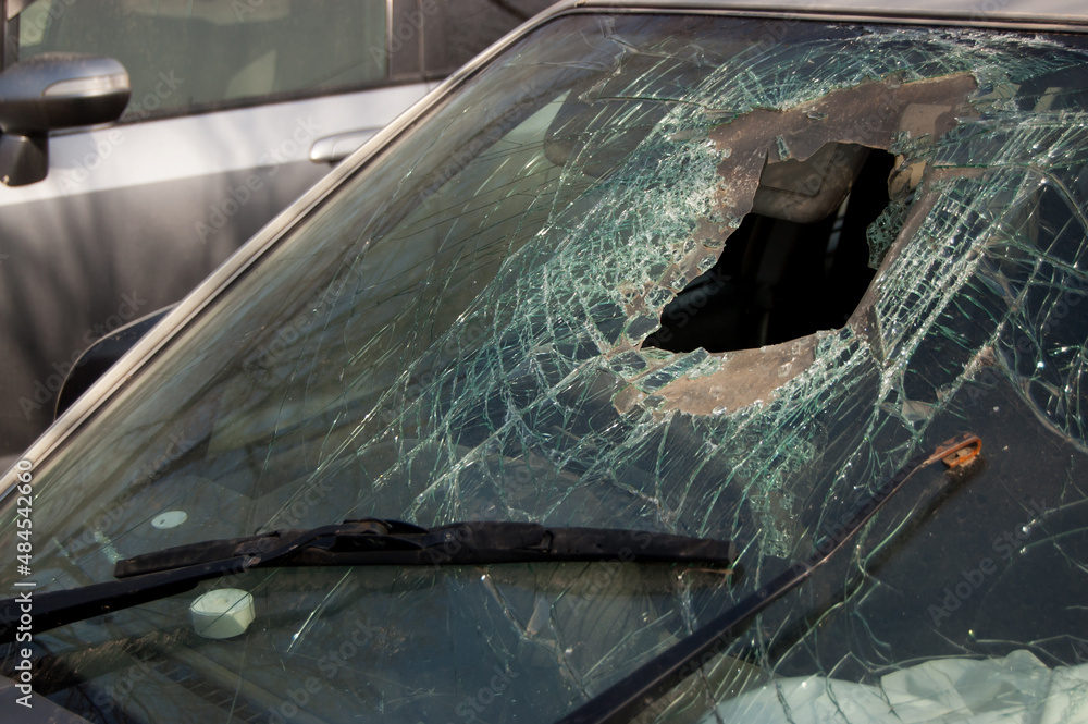 Broken windshield with hole of the car involved in an accident Broken windshield with hole of the car involved in an accident