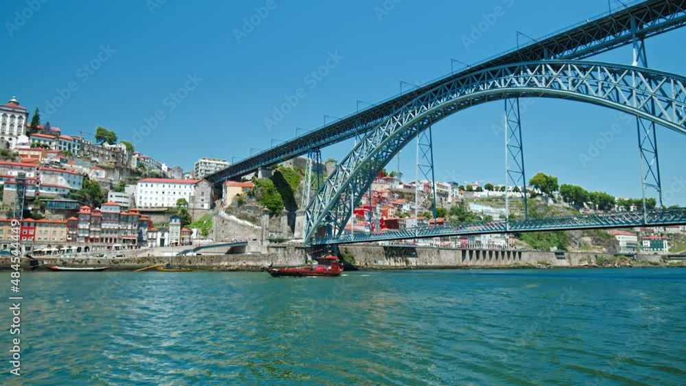 Modern Electric Metro Train on Ponte Luís I Bridge in Porto, Portugal, Europe. Beautiful sunny day and view of Douro River with beautiful colored houses and Portuguese architecture. Modern Electric Metro Train on Ponte Luís I Bridge in Porto, Portugal, Europe. Beautiful sunny day and view of Douro River with beautiful colored houses and Portuguese architecture.