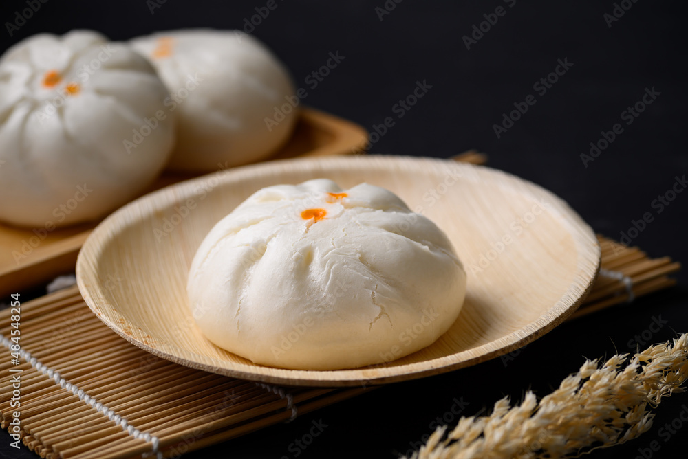 Steamed Chinese bun stuffed with minced pork, egg yolk or sweet on natural plate, Asian food Steamed Chinese bun stuffed with minced pork, egg yolk or sweet on natural plate, Asian food