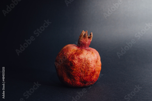 Dried red garnet on a dark background, rough texture of the peel of the fruit. space for text