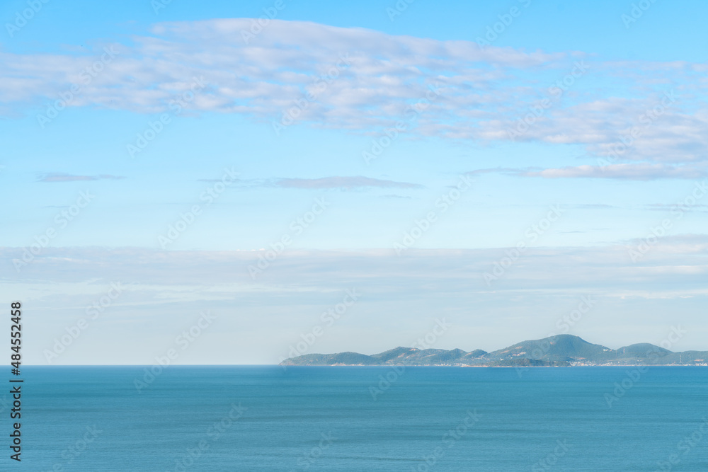 Beautiful blue tone of the sea scape and mountain, wide-area sky with clouds