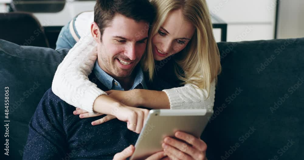 Every moment is a chance to connect. Young couple relaxing at home using a digital tablet. Happy young woman kissing her husband on the cheek while using a digital tablet. Couple bonding at home. Every moment is a chance to connect. Young couple relaxing at home using a digital tablet. Happy young woman kissing her husband on the cheek while using a digital tablet. Couple bonding at home.