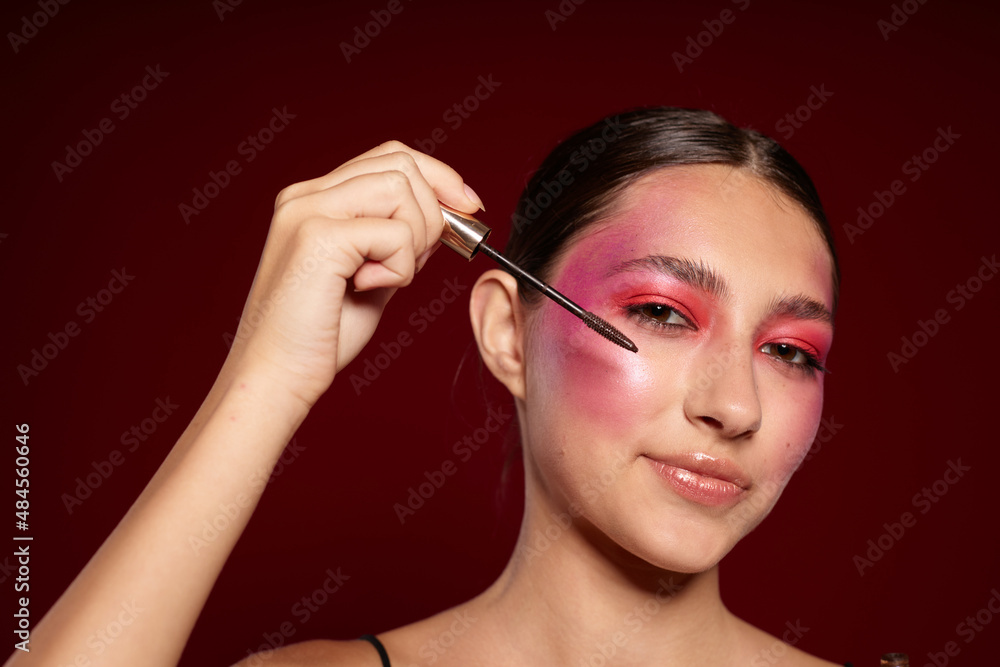 pretty woman Makeup Brush clean leather bright makeup posing pink background unaltered