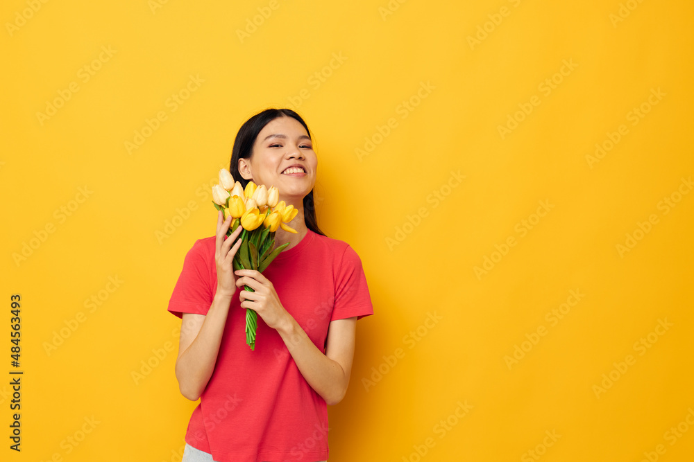 cheerful cute asian girl with a bouquet of flowers yellow background cheerful cute asian girl with a bouquet of flowers yellow background