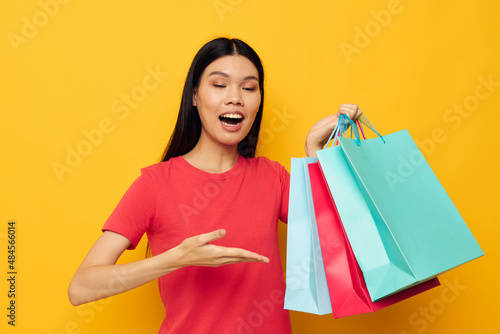 Portrait Asian beautiful young woman with colorful bags posing shopping fun studio model unaltered