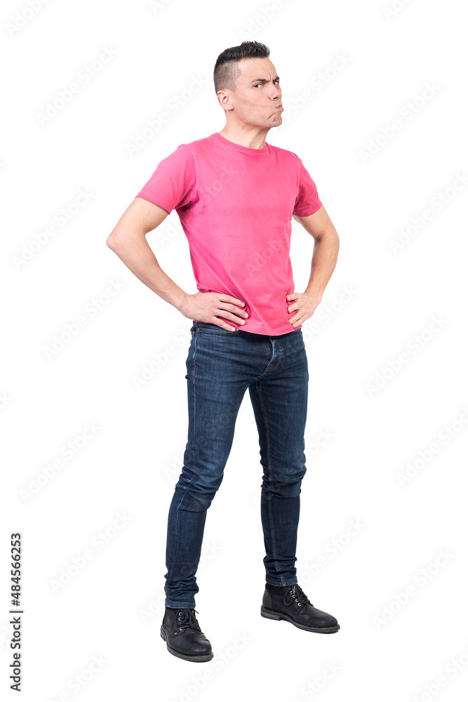Irritate frowning male standing with hands on waist in studio Irritate frowning male standing with hands on waist in studio