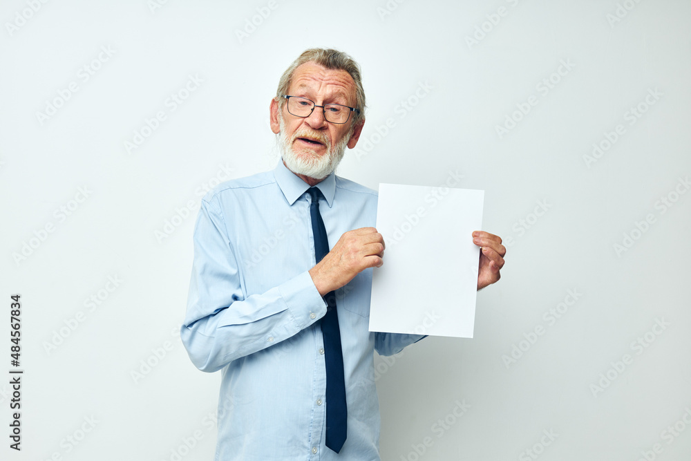 old man holding documents with a sheet of paper light background old man holding documents with a sheet of paper light background