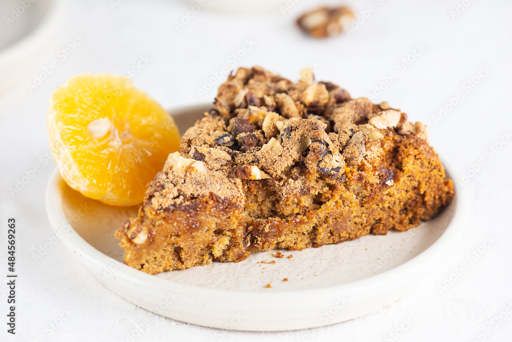 A piece of homemade tangerine pie with nuts in a plate. Healthy food, sugar, gluten and lactose free, vegan. A piece of homemade tangerine pie with nuts in a plate. Healthy food, sugar, gluten and lactose free, vegan.