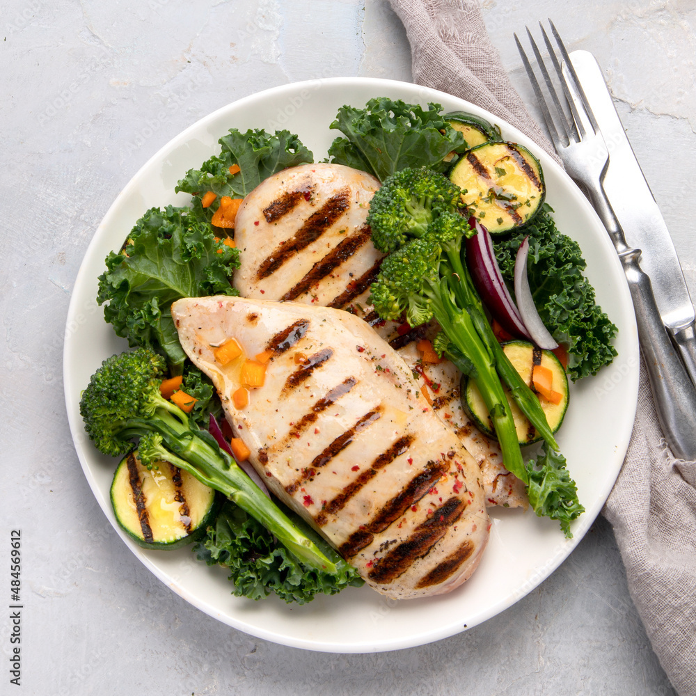 Grilled chicken with vegetables on light background. Grilled chicken with vegetables on light background.
