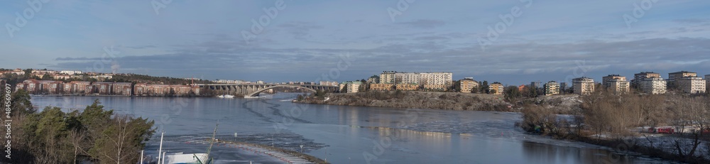 Panorama view over the lake Mälaren, the districts Kungsholmen, Bromma Essingeöarna , bridges, apartment houses on a cliff a cold sunny winter day in Stockholm Panorama view over the lake Mälaren, the districts Kungsholmen, Bromma Essingeöarna , bridges, apartment houses on a cliff a cold sunny winter day in Stockholm