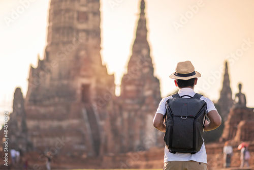 Tourist Man with backpack visiting to ancient stupa in Wat Chaiwatthanaram temple in Ayutthaya Historical Park, summer, solo, Asia and Thailand travel concept photo