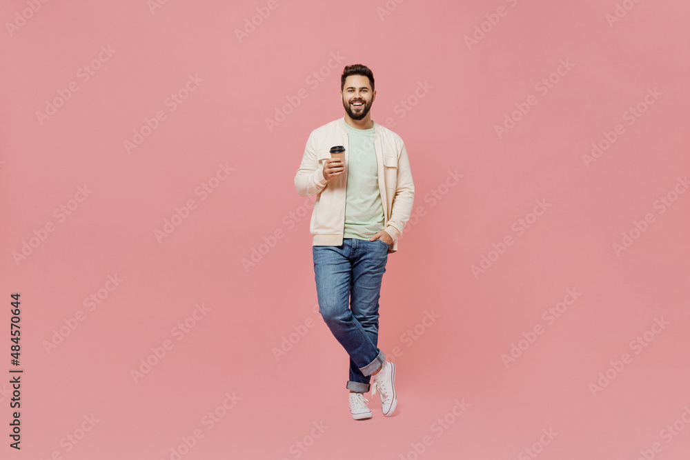 Full body young smiling happy man 20s in trendy jacket shirt hold takeaway delivery craft paper brown cup coffee to go isolated on plain pastel light pink background studio. People lifestyle concept. Full body young smiling happy man 20s in trendy jacket shirt hold takeaway delivery craft paper brown cup coffee to go isolated on plain pastel light pink background studio. People lifestyle concept.