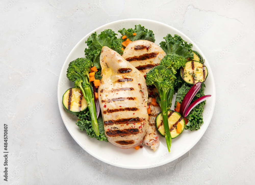 Grilled chicken with vegetables on light background. Grilled chicken with vegetables on light background.
