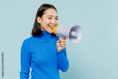 Fotografía Promoter vivid young woman of Asian ethnicity 20s years old wears blue shirt hold scream in megaphone announces discounts sale Hurry up isolated on plain pastel light blue background studio portrait