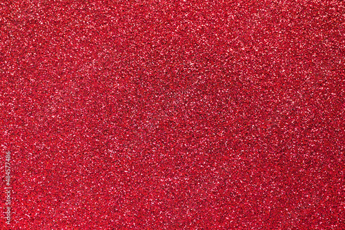 Red glitter background. Sparkle texture. Abstract twinkle background for Valentine or Christmas holiday.