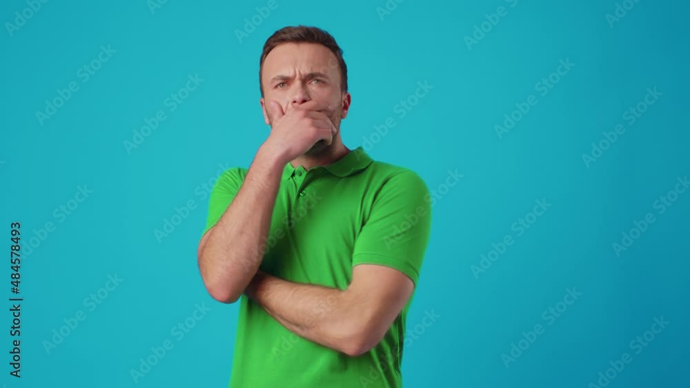 Young handsome man shocked with surprise expression and fear on blue background Young handsome man shocked with surprise expression and fear on blue background