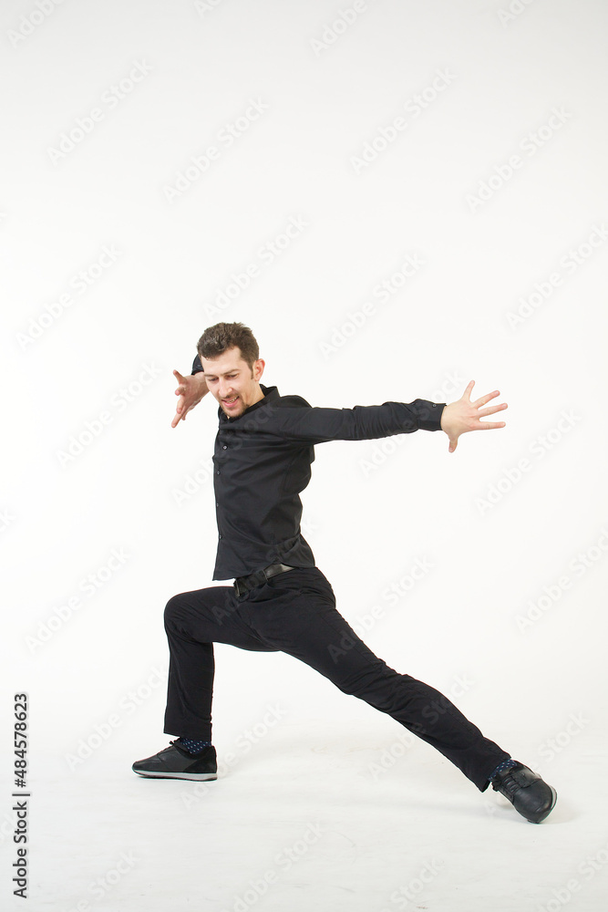A man in black clothes in a dancing pose on a white background. Traditions, culture and customs of the Eastern peoples. A man in black clothes in a dancing pose on a white background. Traditions, culture and customs of the Eastern peoples.