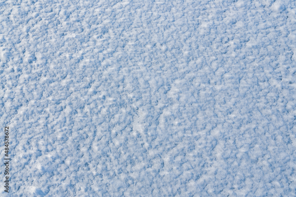 Natural snow texture. The surface of clean fresh snow. Snowy ground. Winter background with snow patterns. Perfect for Christmas and New Year design. Closeup top view.