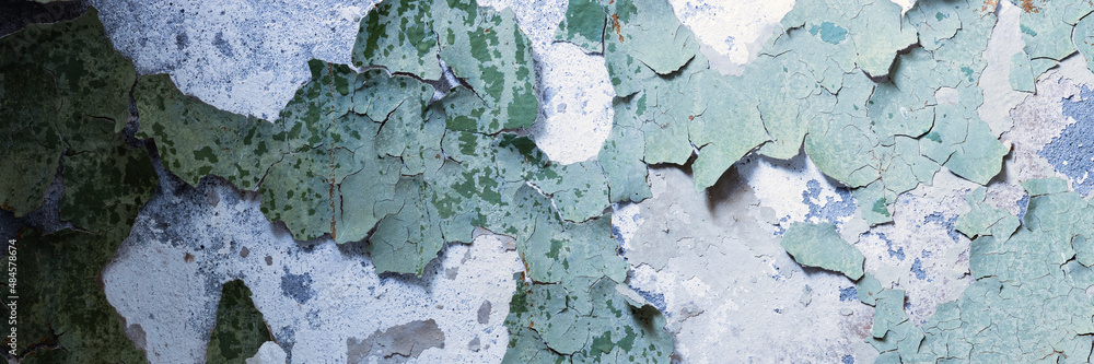 Peeling paint on the wall. Panorama of a concrete wall with old cracked flaking paint. Weathered rough painted surface with patterns of cracks and peeling. Panoramic texture for background and design. Peeling paint on the wall. Panorama of a concrete wall with old cracked flaking paint. Weathered rough painted surface with patterns of cracks and peeling. Panoramic texture for background and design.