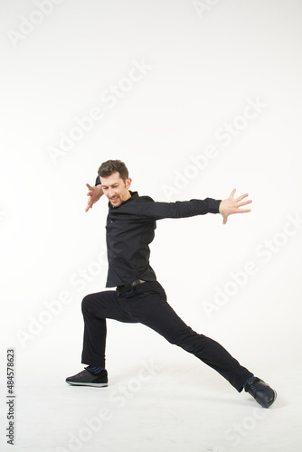 A man in black clothes in a dancing pose on a white background. Traditions, culture and customs of the Eastern peoples.
