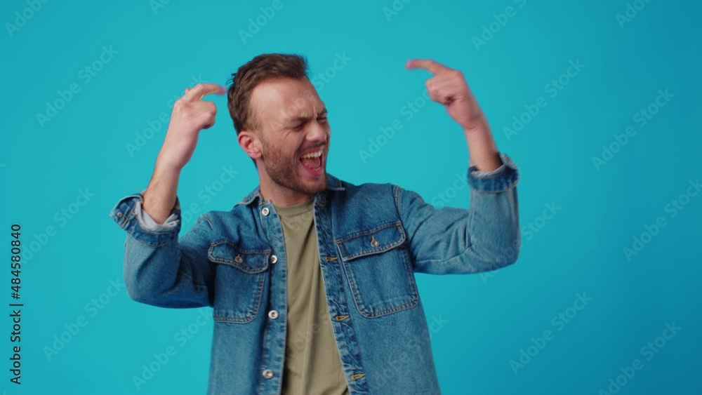 Young man celebrating success on blue background Young man celebrating success on blue background