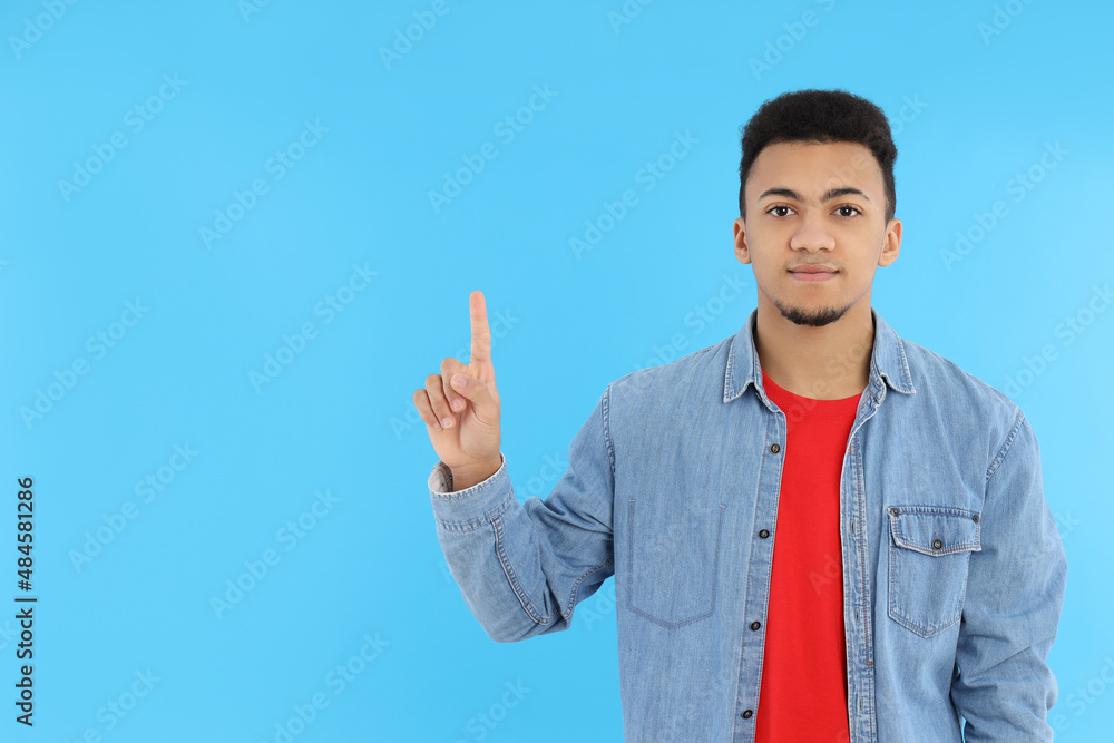 Young man in jeans shirt on blue background Young man in jeans shirt on blue background