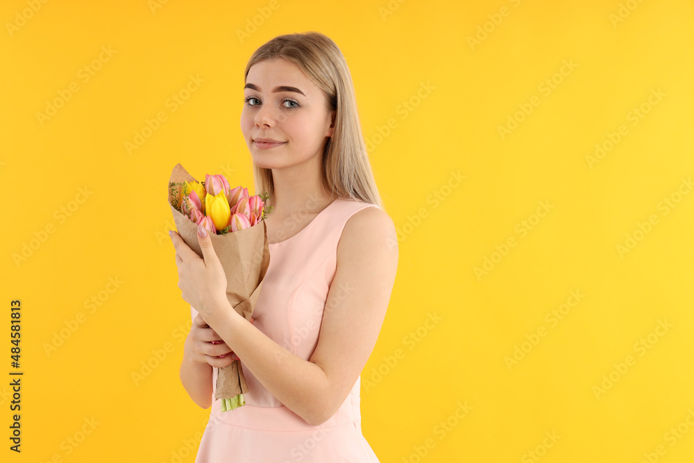 Young woman with bouquet on yellow background Young woman with bouquet on yellow background