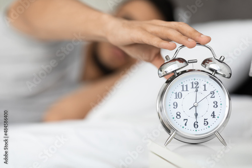 Time To Wake Up. Man Reaching Alarm Clock On Bedside Table, Closeup