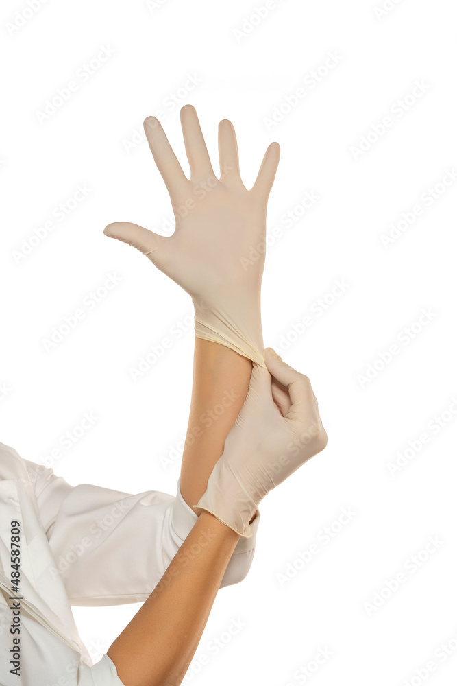 Woman hands putting on a latex gloves Woman hands putting on a latex gloves