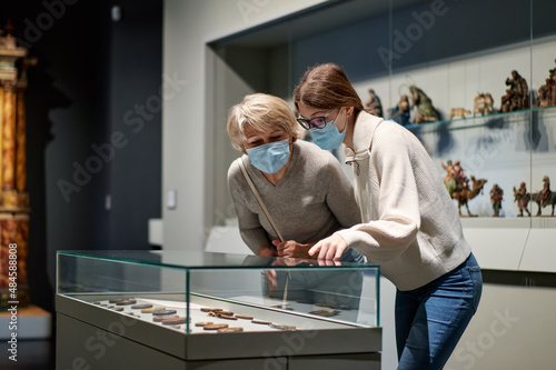 grandmother and granddaughter looking at medieval expositions in museum