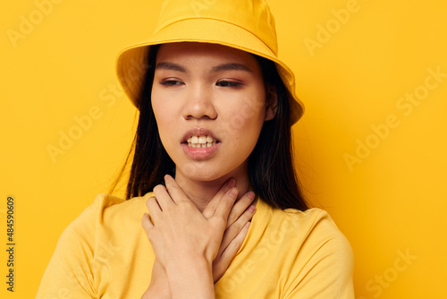 woman wearing a yellow hat posing emotions yellow background unaltered © Tatiana