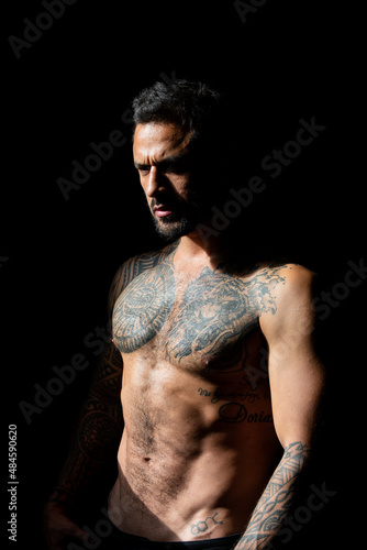 Portrait of handsome man with serious face. Tattooed and elegant hipster. Strong muscular male body, muscles guy. Muscular athletic sexy male, naked torso.