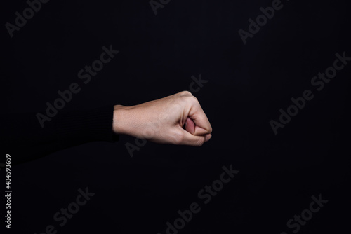 Caucasian person clenched fist isolated on black background. Copy space. Domestic violence. Physical and psychological abuse, relative aggression, gaslighting.