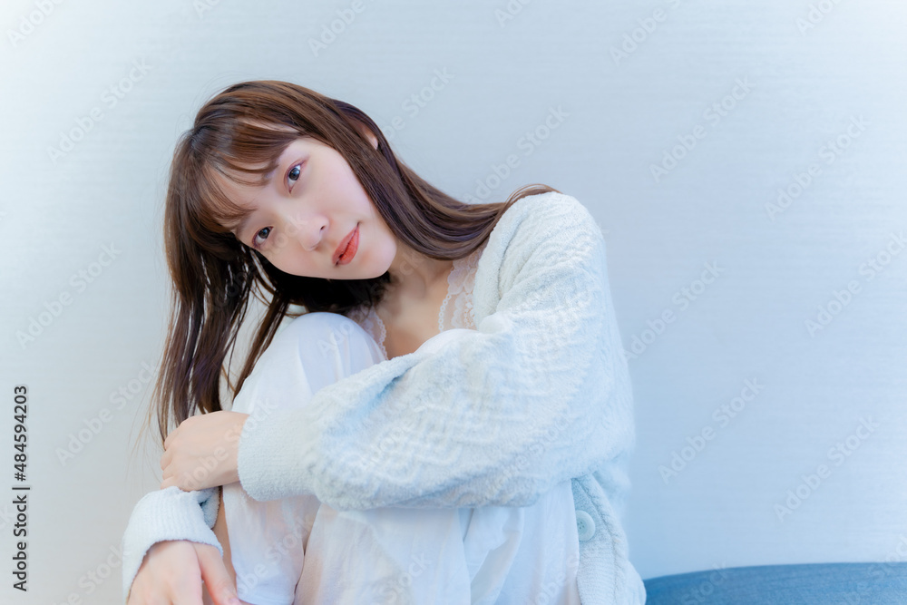 座りながらこちらを見つめるモデル女性 座りながらこちらを見つめるモデル女性