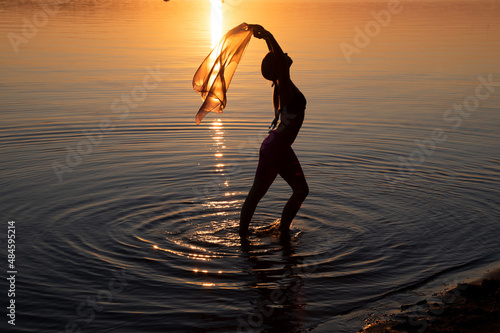 Girl dancing in water. Woman practice Yoga on the beach. Sunset evening © Marina