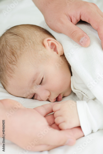 Newborn baby in mother's hands sleeping on