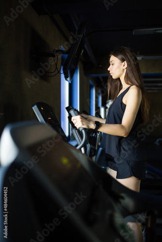 Young girl trainer performs exercise in modern gym club