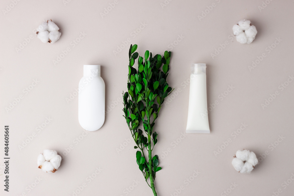 Cosmetic skin care products with flowers on grey background. Flat lay Cosmetic skin care products with flowers on grey background. Flat lay