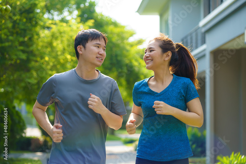 Asian couple are jogging in the neighborhood for daily health and well being, both physical and mental and simple antidote to daily stresses and to socialize safely..