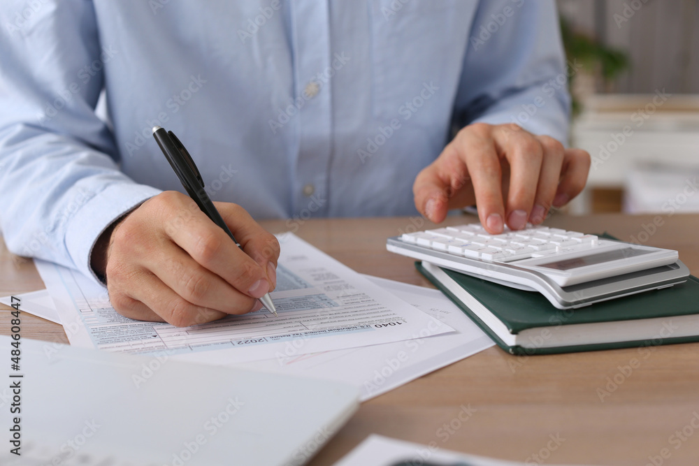 Tax accountant with calculator working at table in office, closeup Tax accountant with calculator working at table in office, closeup
