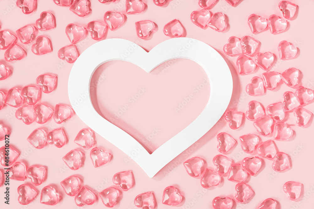 St Valentines day pink background banner. Many glass hearts around white heart frame flat lay. Love or wedding concept St Valentines day pink background banner. Many glass hearts around white heart frame flat lay. Love or wedding concept