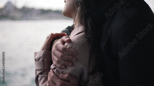 man hugging a girl in a raincoat close-up