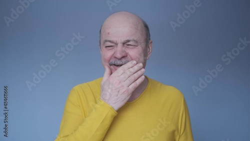 Senior man being bored yawning tired covering mouth with hand
