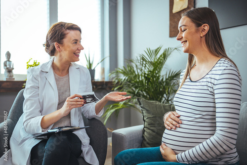 Fotografía Young  woman smiles while looking at her baby's ultrasound image