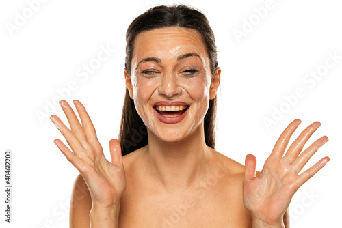 Portrait of a smiling woman with smeared makeup removing lotion on her face