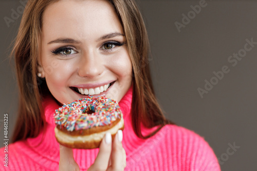 Closeup portrait young smiling woman with donut