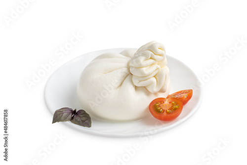 Italian burrata homemade organic white soft milk cheese served with sliced red cherry tomatoes and basil leaves on plate as appetizer or snack isolated on white background
