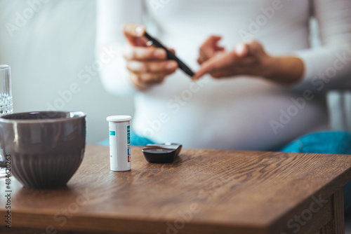 Diabetes monitoring with blood sugar test, glucose measurement on aged woman patient fingertip for analyzing insulin-deficient illness, diabetic disease awareness and control